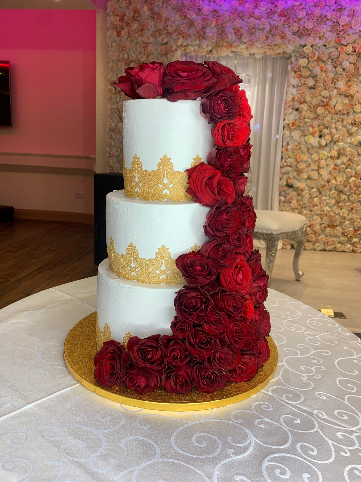Three-tier wedding cake with red roses