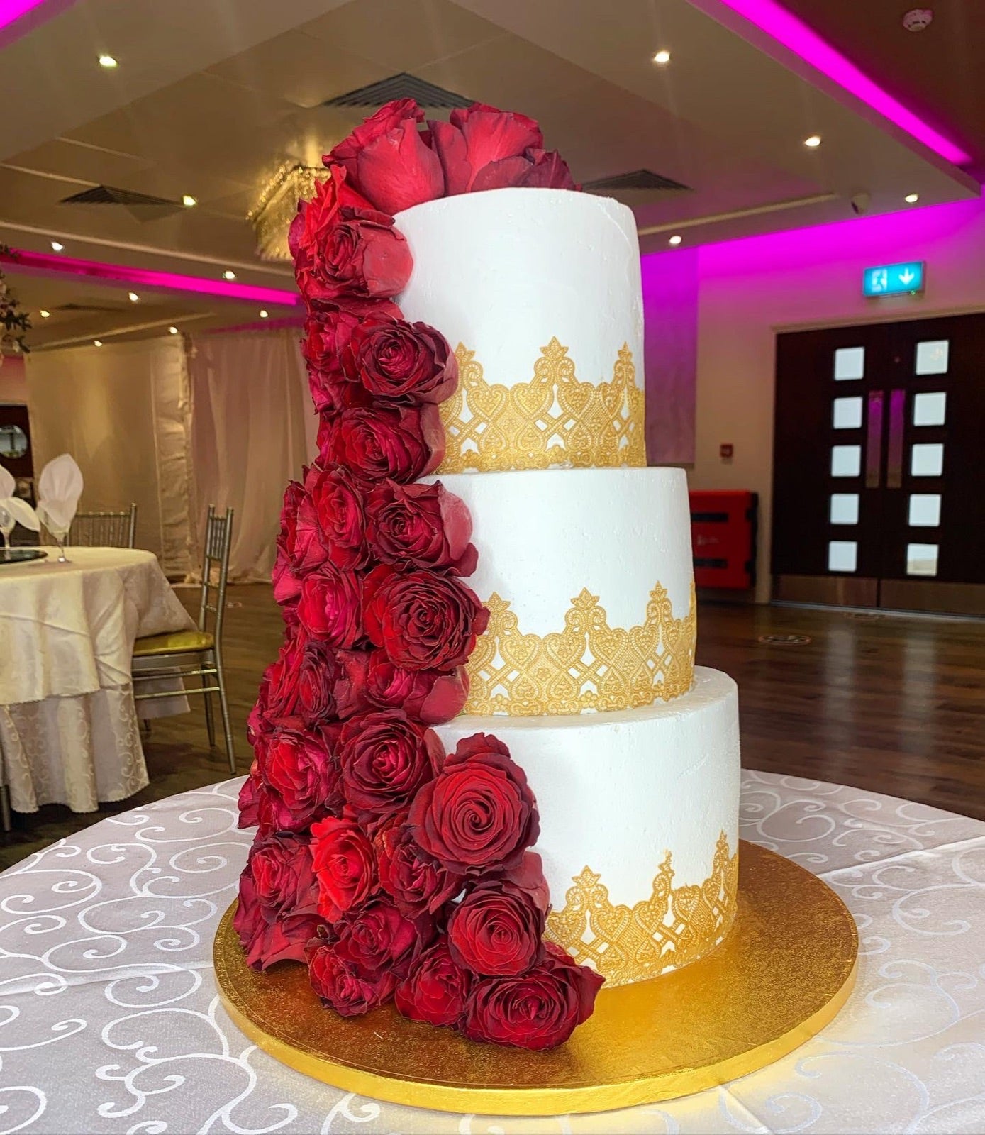 Three-tier red rose and gold celebration cake