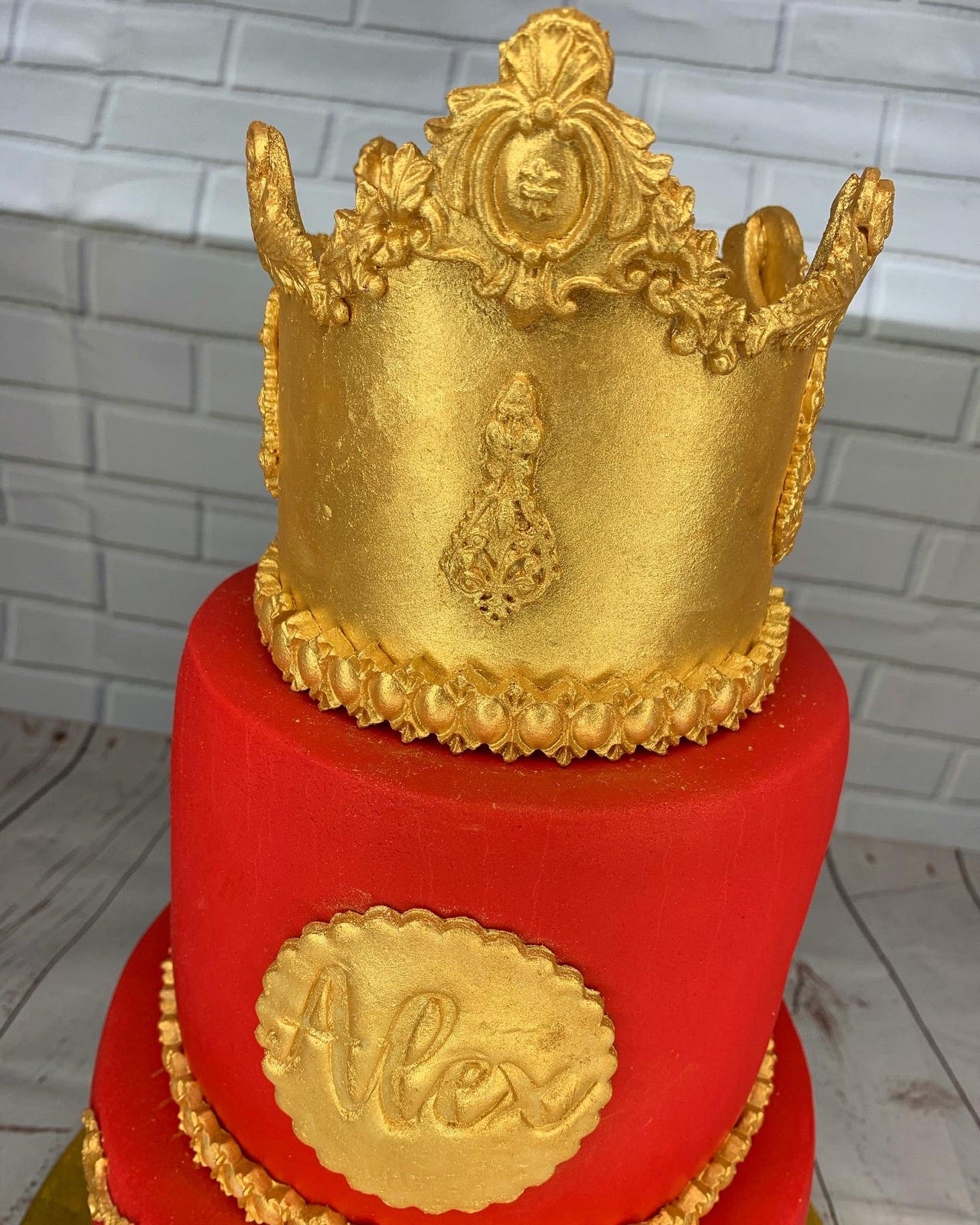 Red birthday cake with a gold crown topper