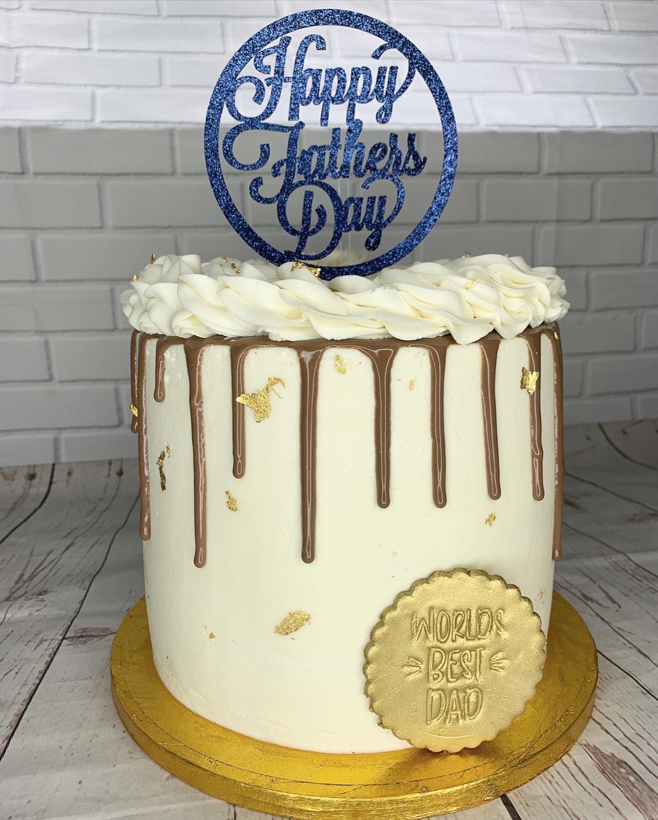 White drip cake with a blue birthday topper