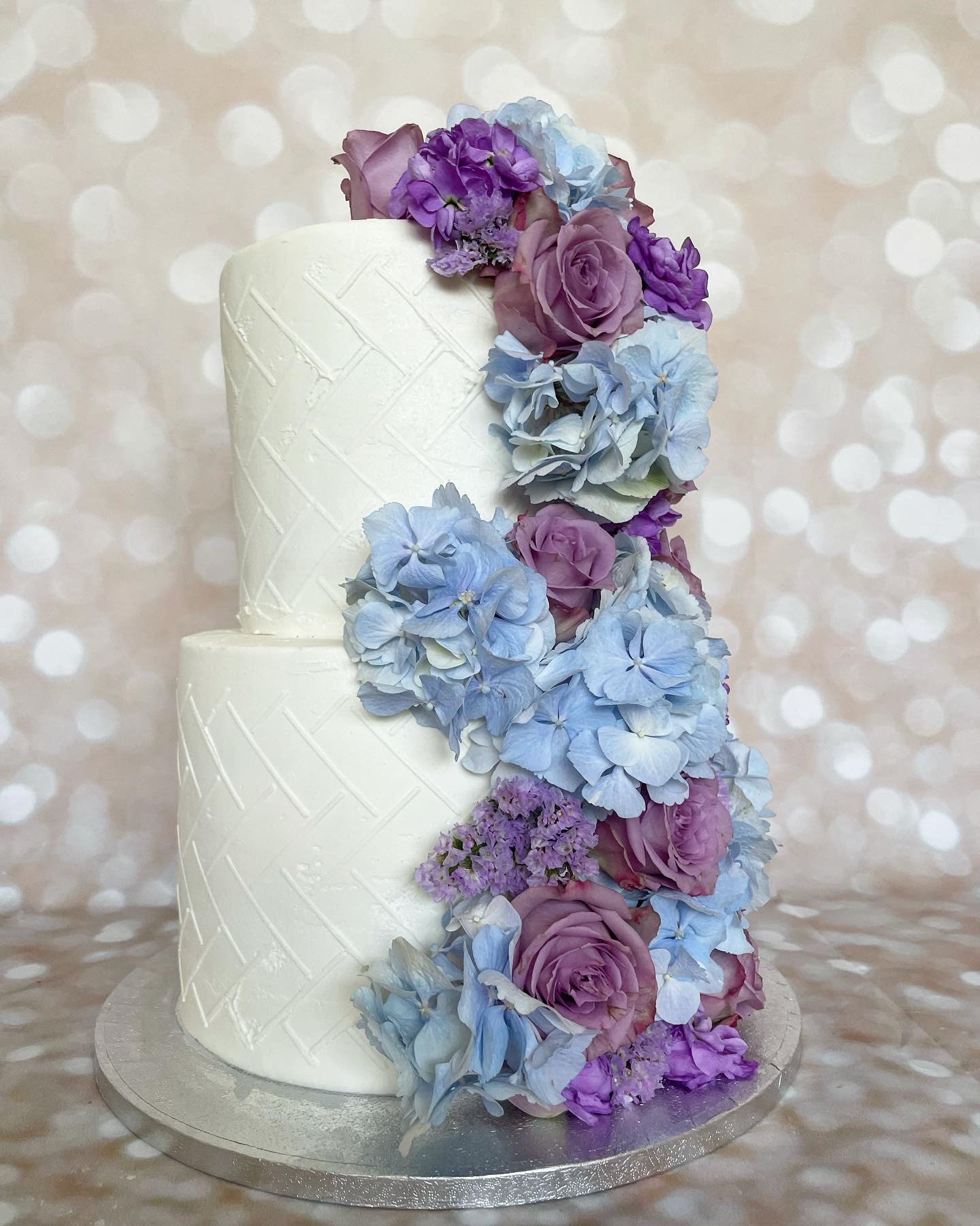 White wedding cake with purple flowers
