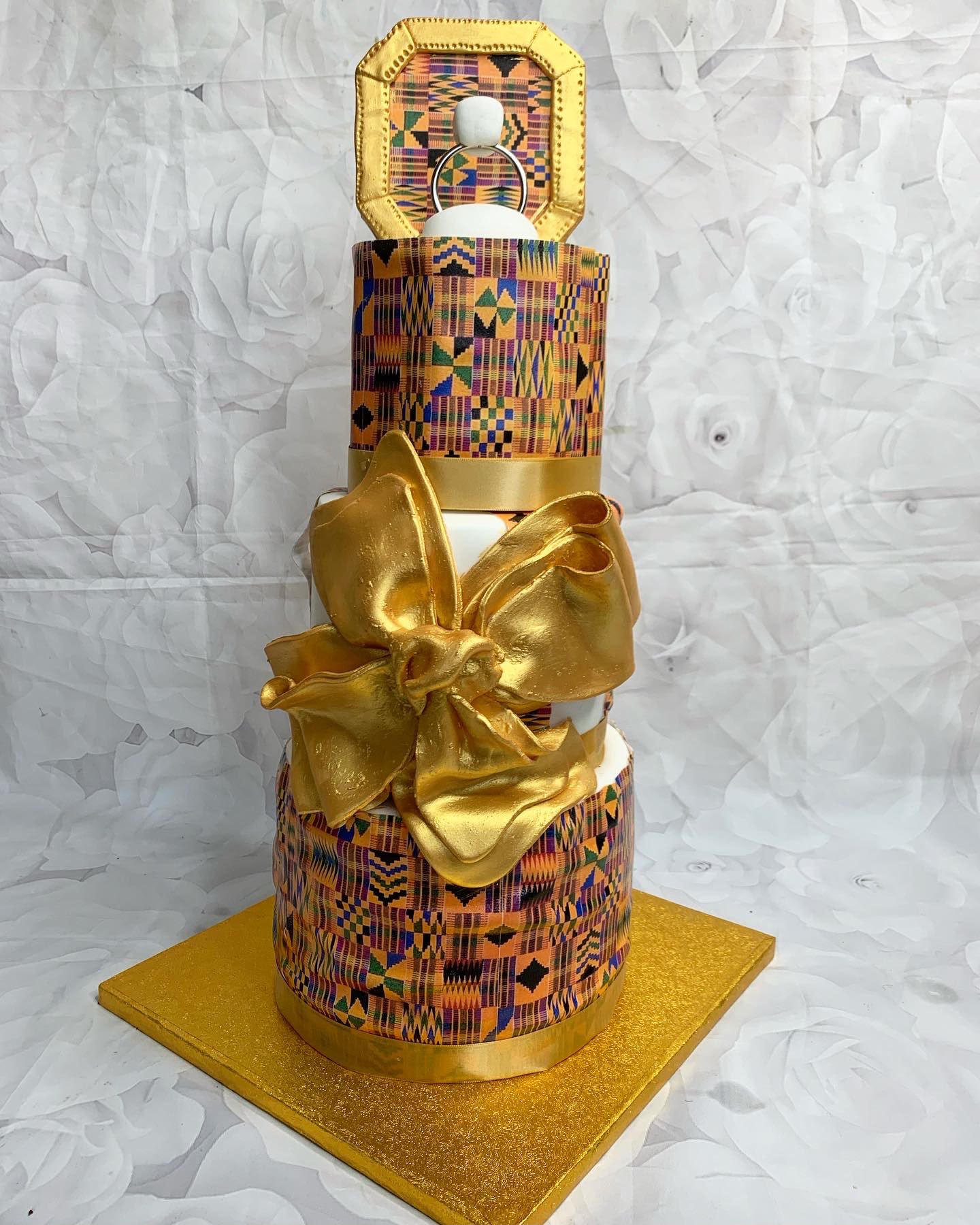 Gold Kente patterned tiered celebration cake